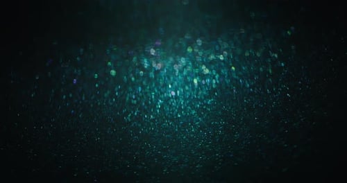 Abstract Teal Bokeh Lights Sparkling on Dark Background