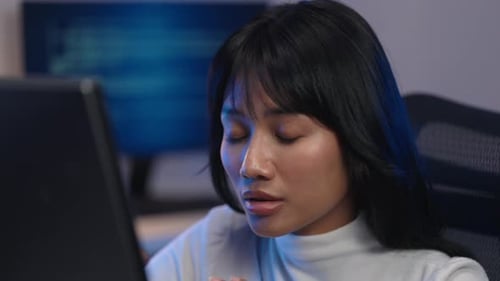 Asian Woman Developer Explaining Code In Modern Tech Office