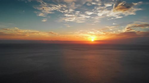 Aerial View of Sun Setting Over Ocean Waters