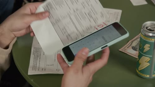 Young Students Calculating Utility Bills on Smartphone