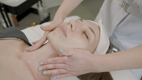 Woman Receiving Facial Massage in Beauty Salon