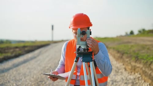 Surveyor Engineer Measuring Land with Theodolite on Construction Site