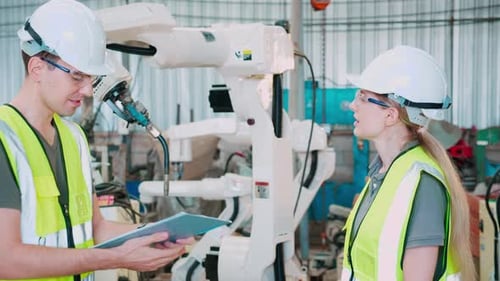 Engineers Discussing Robotics Manufacturing in Factory Setting