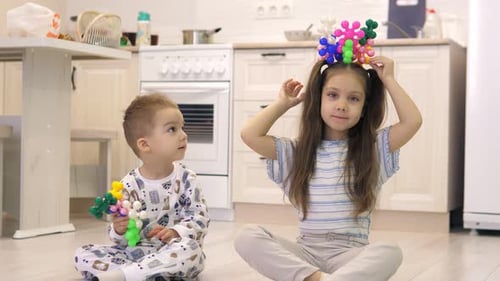 Two Children Brother and Sister Play Colorful Educational Games on the Floor