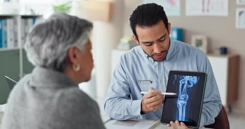 Doctor Explains Knee X-Ray to Senior Patient