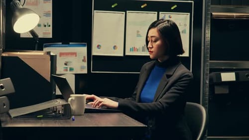 Woman Working at Laptop in Dark Office