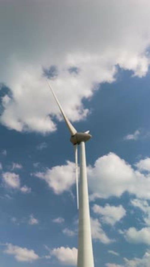 Exploring the Beauty of Wind Turbines Swaying Gracefully Under a Clear Blue Sky in the Netherlands