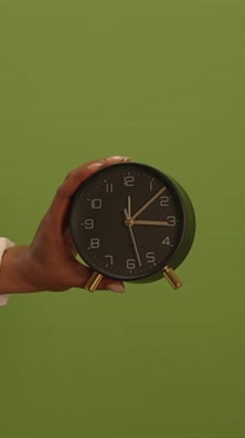A Classic Alarm Clock Positioned Against a Beautiful Green Background Rich in Artistic Detail