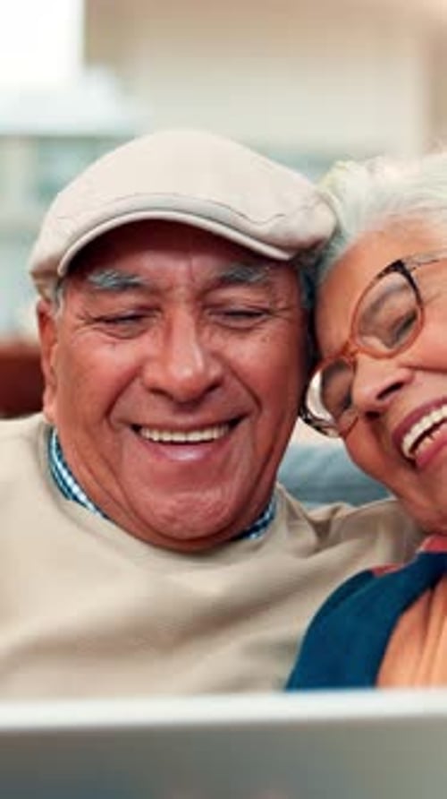 Happy Senior Couple Laughing While Looking at Tablet