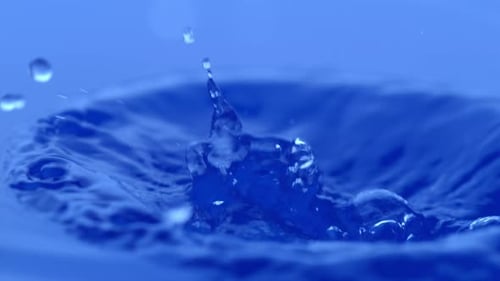 Water Droplet Splashes on Blue Background in Slow Motion