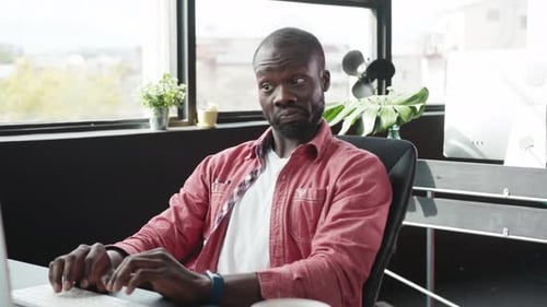 A Focused Professional Intently Working on Their Computer in a Modern Office Environment