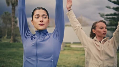 Women Stretching Arms in Outdoor Urban Park