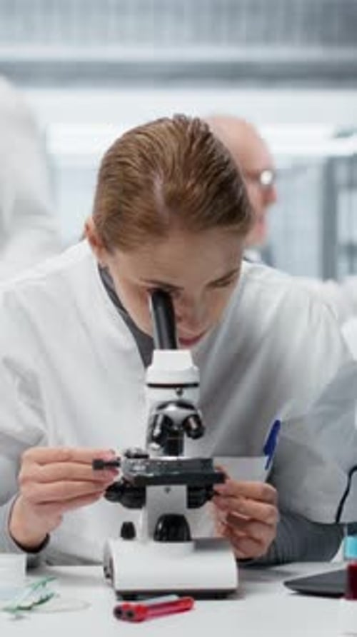 Female Scientist Using Microscope in Modern Laboratory