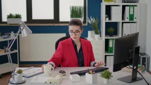 Young Woman Working at Computer and Drinking Coffee