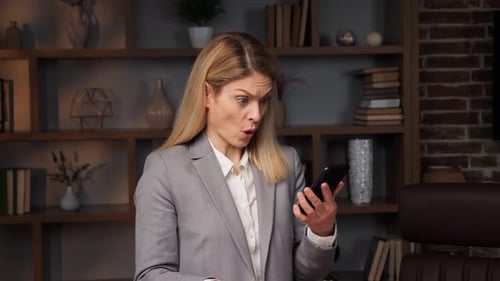 Worried Woman With Smartphone at Workplace