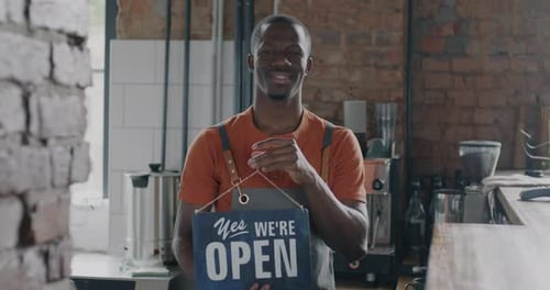 Cafeteria Owner African American Man Changing Closed to Open Sign Advertising Cafe Smiling