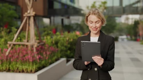 Woman in Blazer Using Tablet in Urban Setting