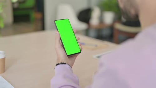 Rear View of Man Using Smartphone with Green Chroma Screen