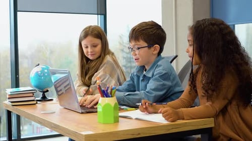 Happy Diverse Pupils with Laptop in Classroom