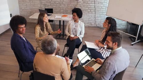 Group of diverse business people having a meeting while sitting in circle.
