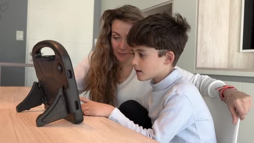 Boy and Woman Use Tablet Indoors During the Day