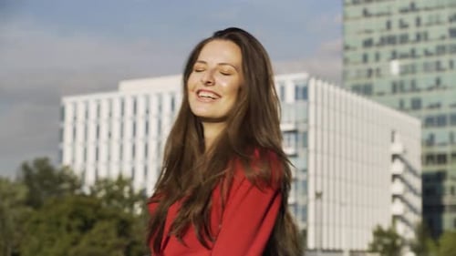A Young Beautiful Caucasian Businesswoman Celebrates and Laughs Office Buildings