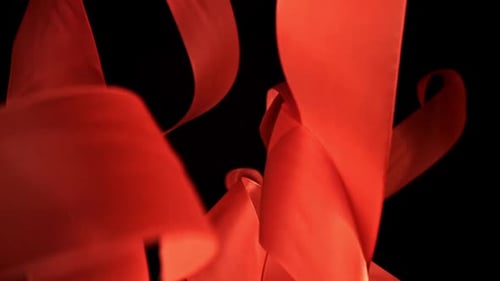 Abstract Video of Red Ribbon Flowing Against Black Background