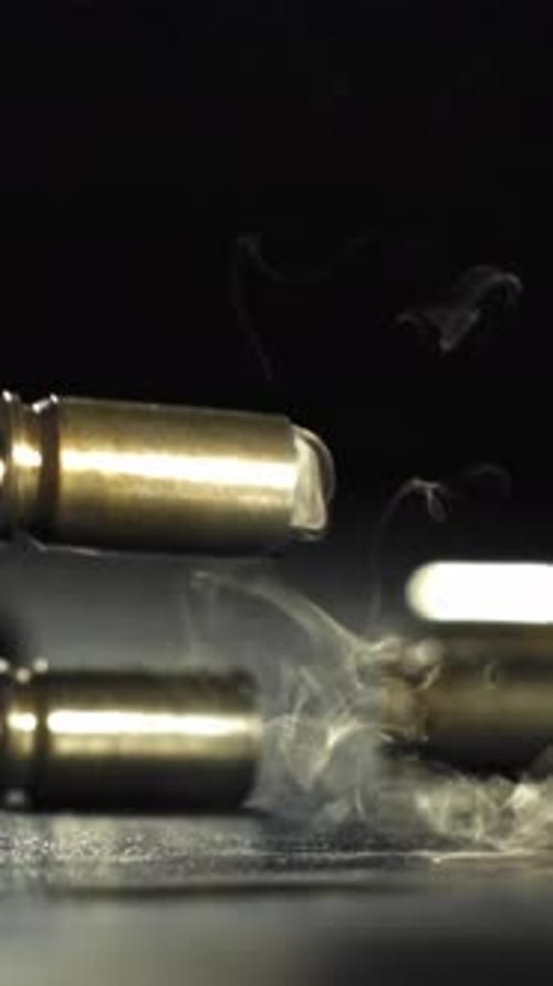 Patronen aus einem Pistolenschuss fallen zu Boden, gefilmt mit einer Hochgeschwindigkeitskamera mit 1000 Bildern pro Sekunde