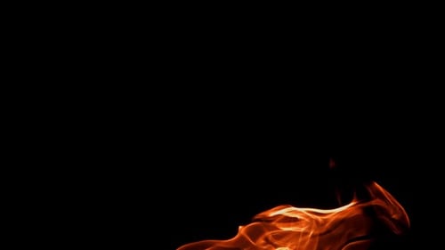 Abstract fire flames burning against black background zooming in