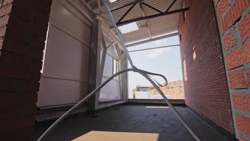 Cable in Doorway of Empty Room with High Corrugated Ceiling