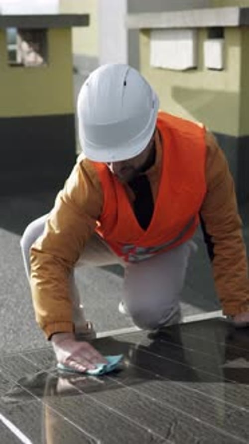 Worker cleaning solar panels, emphasizing maintenance and energy efficiency.