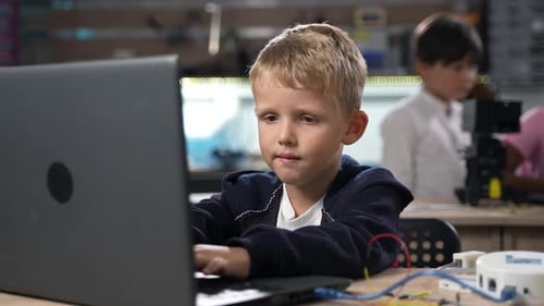Portrait of Boy Programming Software for Robotics