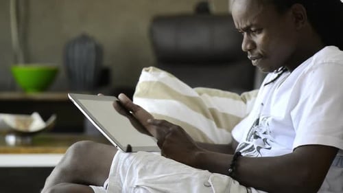 Man Relaxing on Sofa Using Tablet Indoors