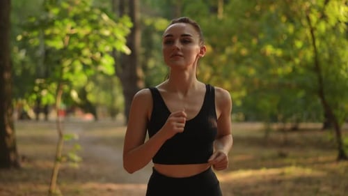 Woman Jogging in an Urban Park on a Sunny Day
