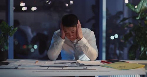 Stressed Man at Desk Late at Night
