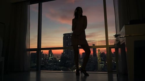 Woman Dancing at Sunset in City Apartment