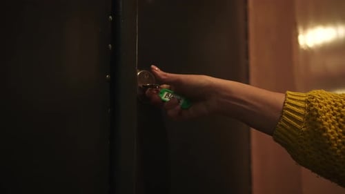 Hand Unlocking Door Lock with a Key in Evening Light