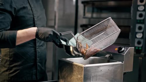 Chef Preparing French Fries in a Restaurant Kitchen