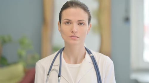 Doctor in White Coat Stares at Camera