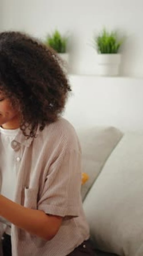 Young Woman Using Smartphone While Sitting on Couch