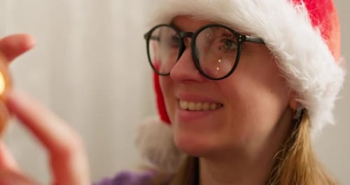 Smiling Woman Decorates Christmas Tree at Home