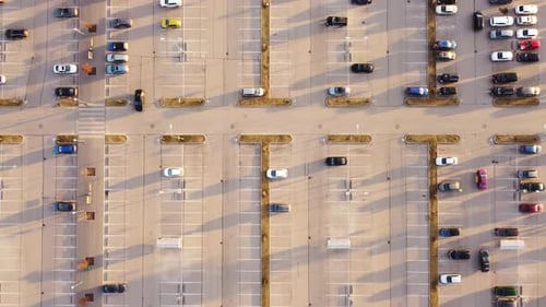 Huge but almost empty parking lot on sunny evening, aerial top down ascend view