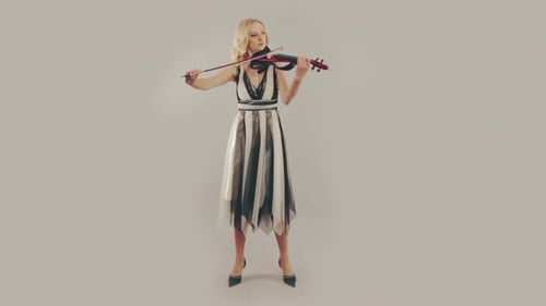Elegant Woman Plays Violin in Studio Setting