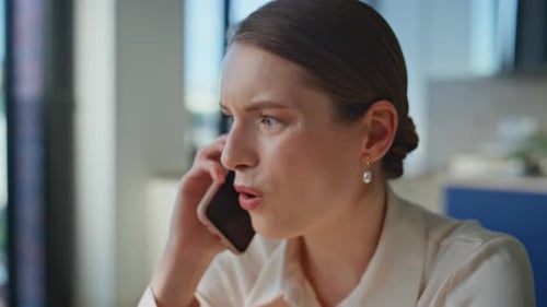 Irritated Lady Arguing Smartphone Discussing Work Trouble in Office Closeup