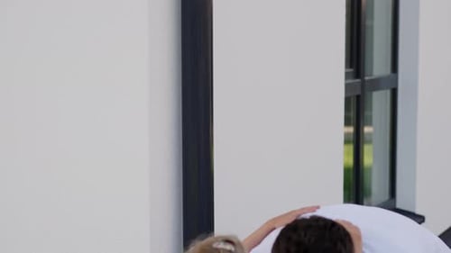 Happy Family Hugging Outside Suburban Home on Sunny Day