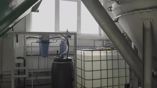 Bulk Container with Liquid in Near Workshop Window