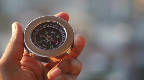 Close up of a hand holding a compass