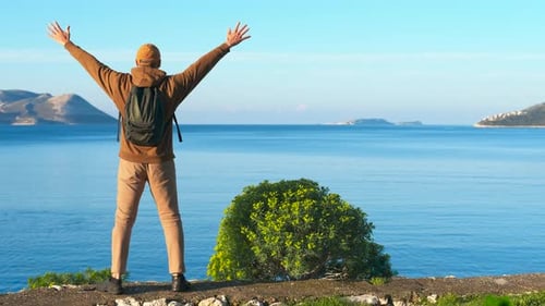 Tourist Enjoying Freedom with Open Arms By the Sea