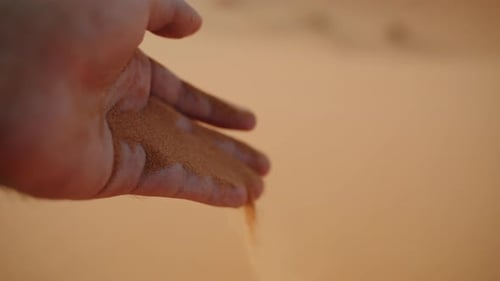 Close-Up of a Hand Releasing Fine Desert Sand