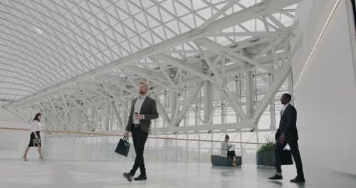 Group of Businesspeople in Suits Walking in Modern Innovative Office Center